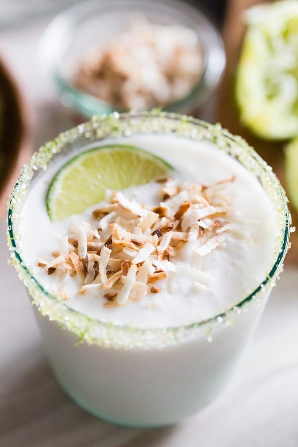 &iexcl;Esta margarita congelada de lima y coco es justo lo que orden&oacute; su verano! ENVASADO lleno de dulce sabor a coco y embellecido con jugo de lima. En lugar de sal, opt&eacute; por bordear el c&oacute;ctel con az&uacute;car de lima y cubrirlo con coco tostado.