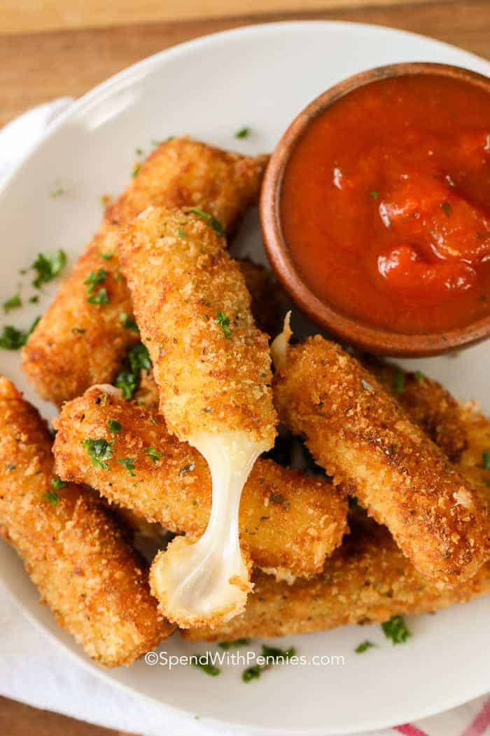 Palitos de queso caseros pegajosos con salsa marinara listos para comer