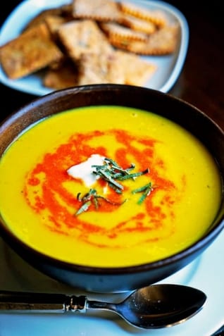 Sopa de calabaza con salsa de pimiento rojo asado y salvia frita