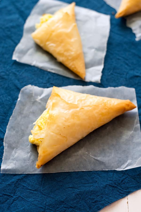 Tiropita: pasteles de mano de estilo griego, ligeros, crujientes y rellenos de queso feta. Ideales como aperitivos de fiesta o servidos con una ligera ensalada de verano.