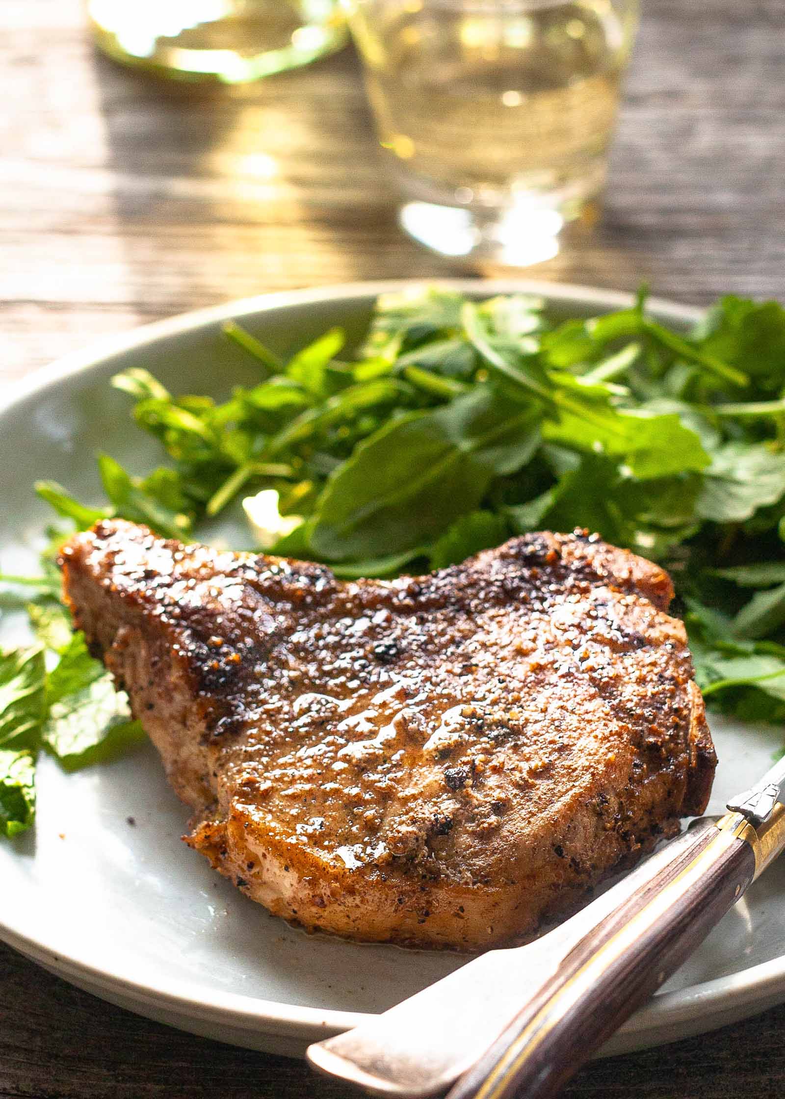 Easy Pork Chop Recipe pork chop on plate with greens