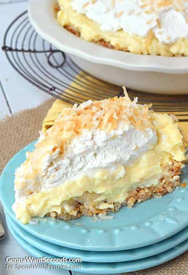 Slice of Coconut Banana Cream Pie on a stack of three blue plates
