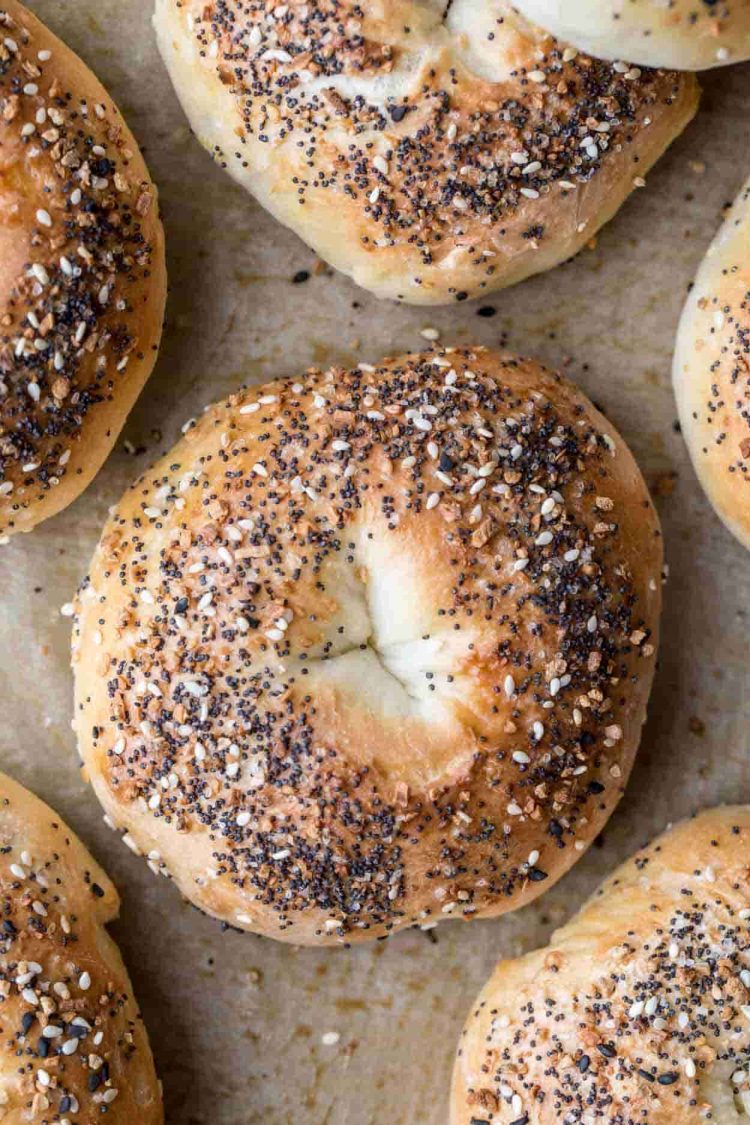 Celý recept na bagel pokrytý veškerým kořením položeným na plechu na pečení.