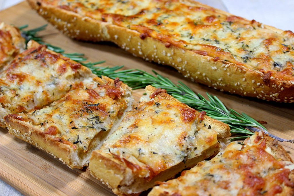 Tranches de pain à l'ail et au fromage avec du romarin frais.
