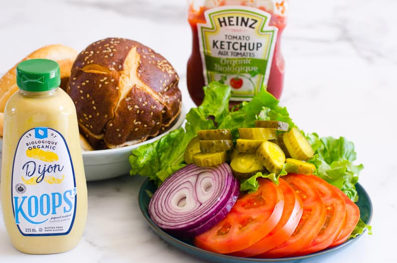 Bollos, verduras, ketchup y mostaza para preparar hamburguesas de pavo