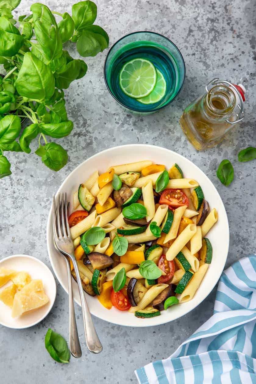 Pasta in a white bowl with fresh basil