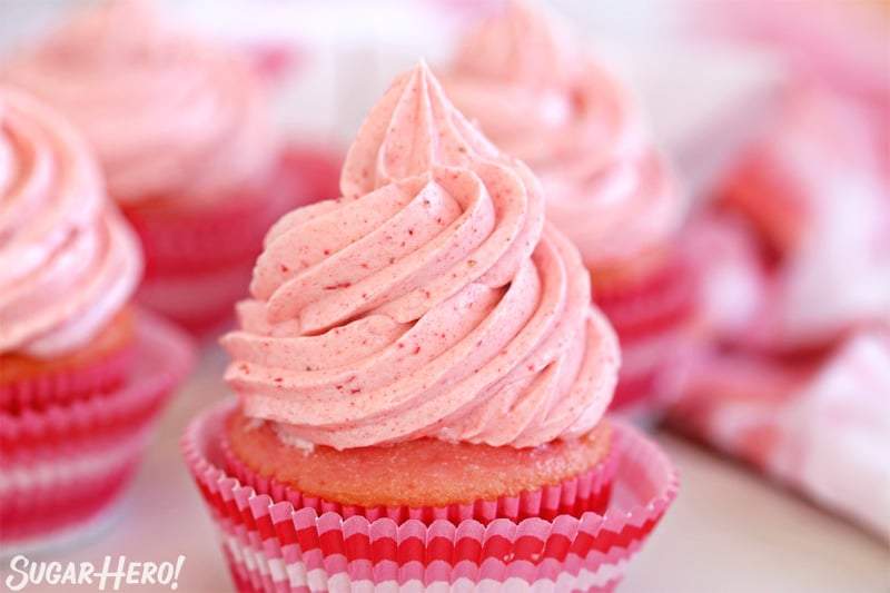 Glaseado de crema de mantequilla de fresa - primer plano de remolino de glaseado de fresa rosa en un pastelito | De SugarHero.com