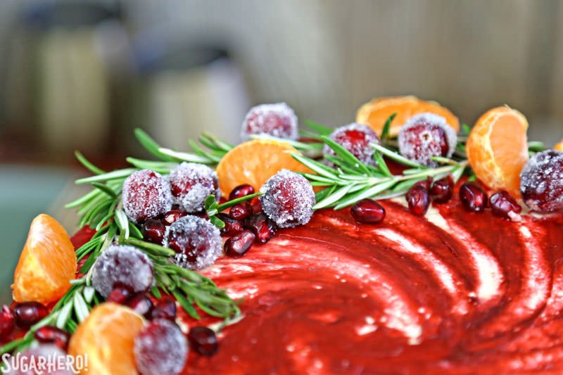 Brown Sugar Cranberry Cake - primer plano de la parte superior del pastel con fruta fresca y romero | De SugarHero.com