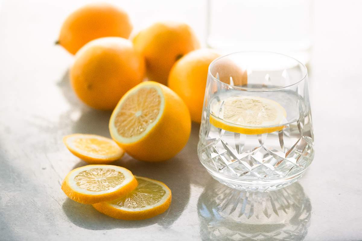 Un vaso de agua de limón con limones en rodajas