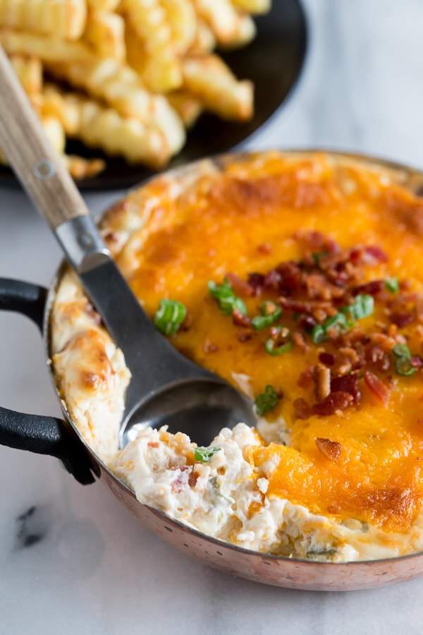This warm loaded baked potato dip is served hot and full of delicious flavor. Packed full of cream cheese, sour cream, green onions, bacon and of course CHEESE! Perfect when served with french fries or potato chips!
