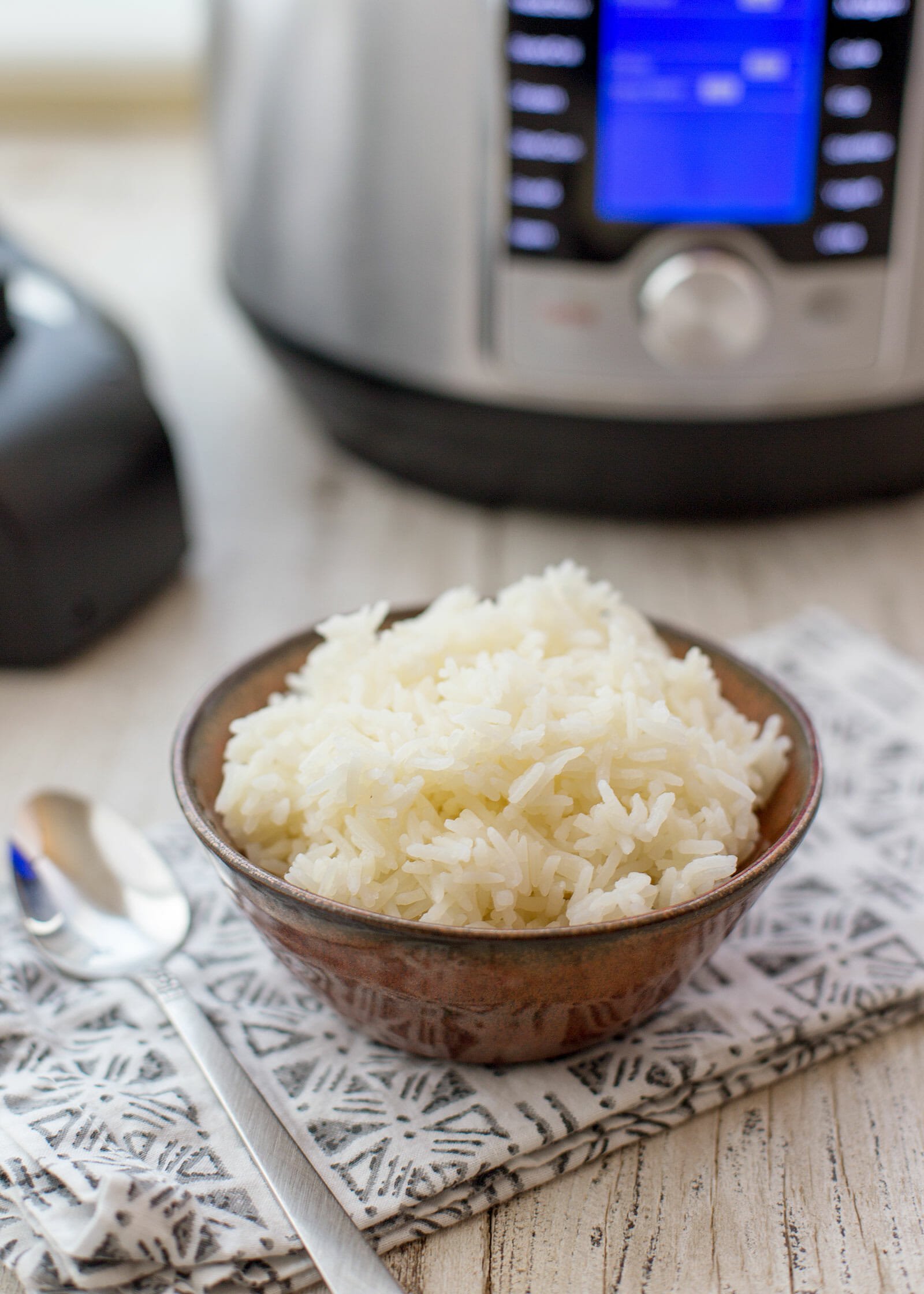A bowl of instant pot rice with the instant pot in the background