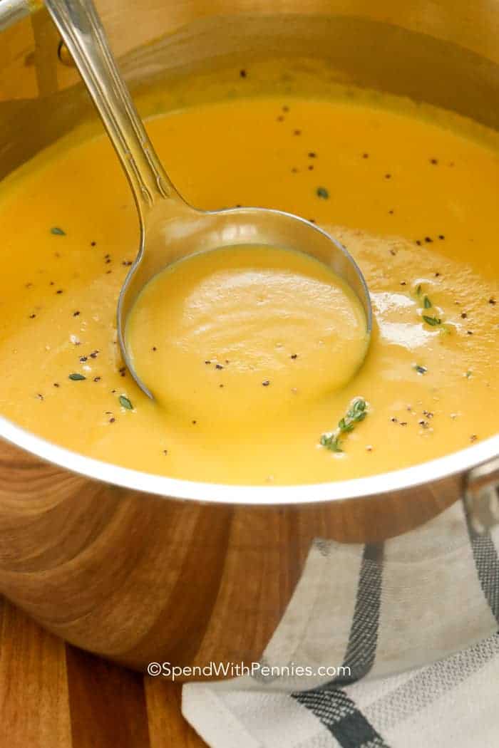 Sopa de calabaza butternut servida con un cucharón 