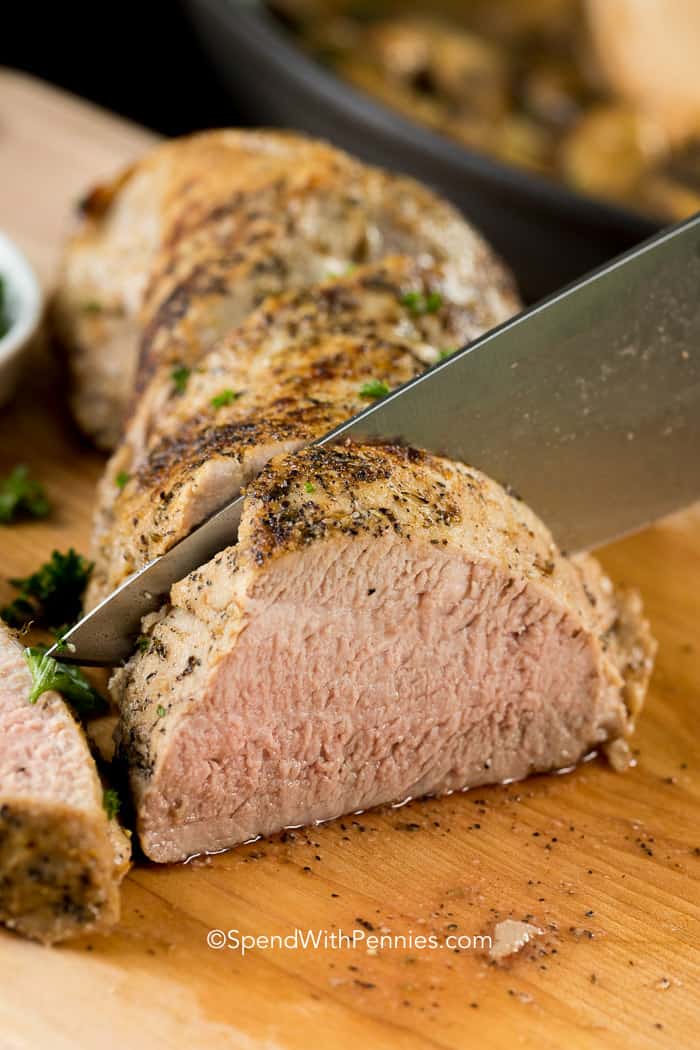 knife cutting into pork tenderloin