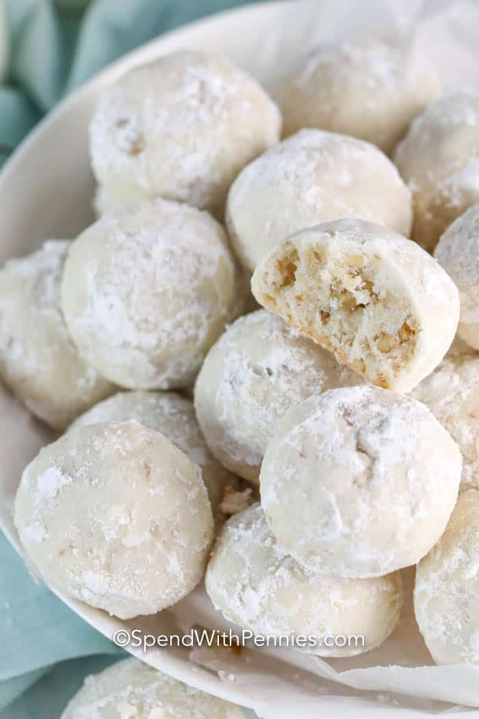 Snowball cookies with a bite taken out of one in a white bowl