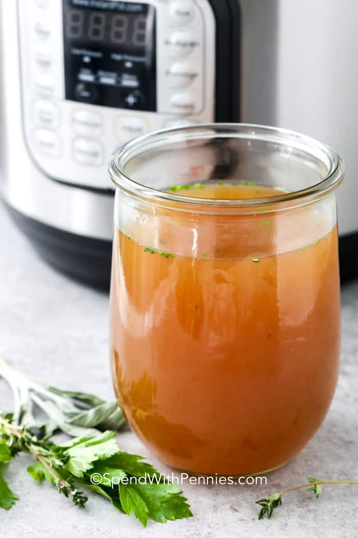 Instant pot turkey broth in a clear jar with instant pot in the background