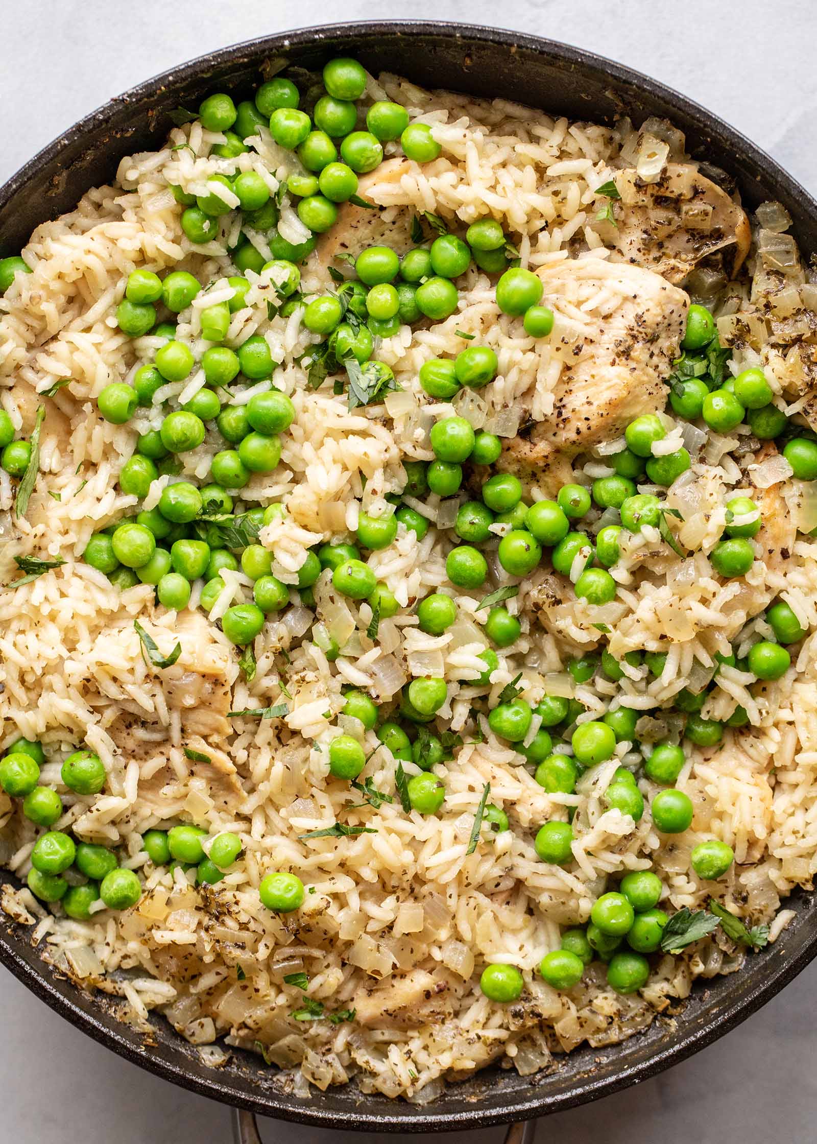 Chicken and rice with peas made in a skillet on the stove