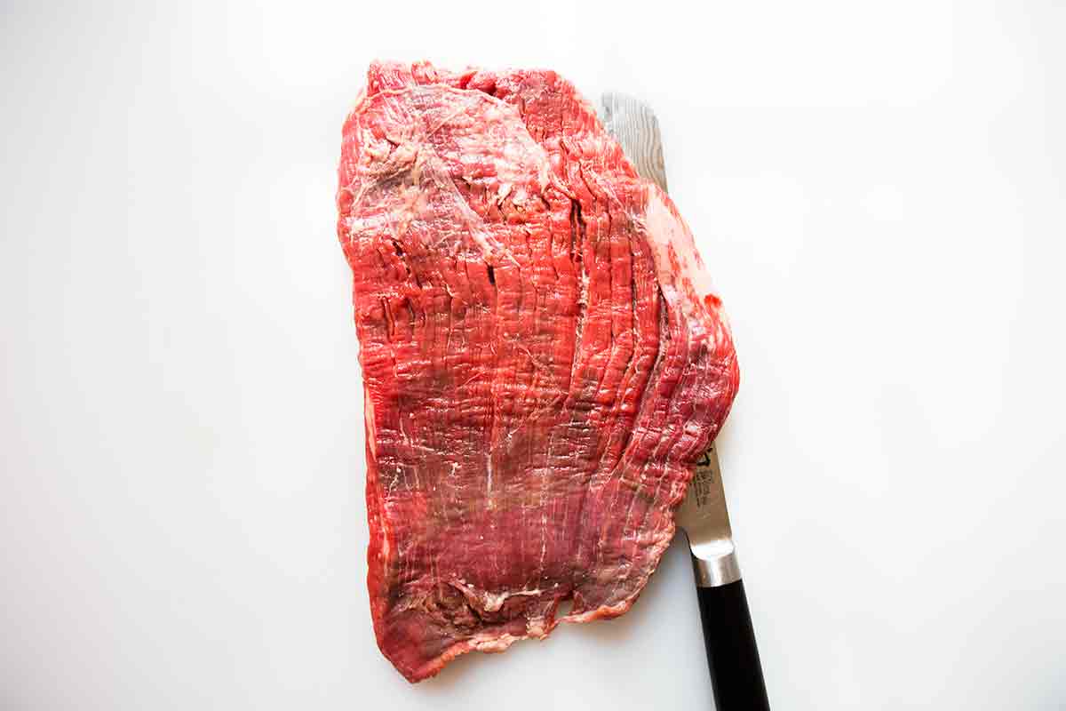cuchillo colocado en la misma dirección de la veta de la carne del filete de falda
