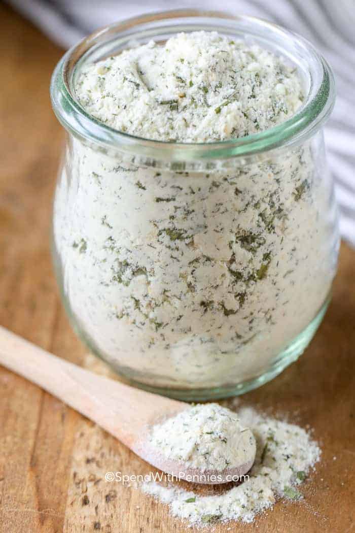 Clear jar of Ranch Seasoning Mix with spoonful laying next to it