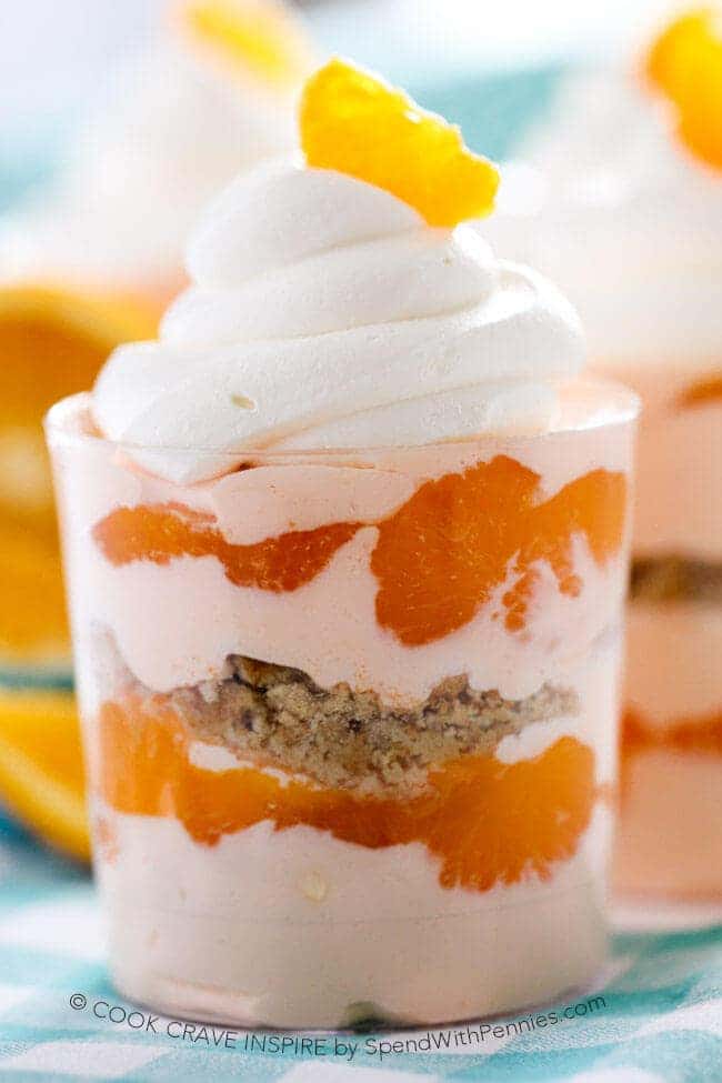 Primer plano de Creamsicle Parfaits con cobertura batida y guarnición de naranja