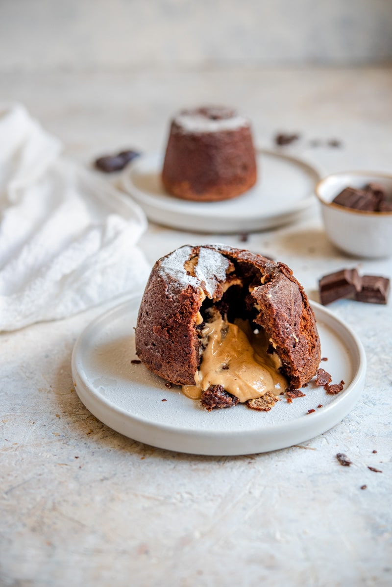 Chocolate lava cakes on a plate with peanut butter oozing out