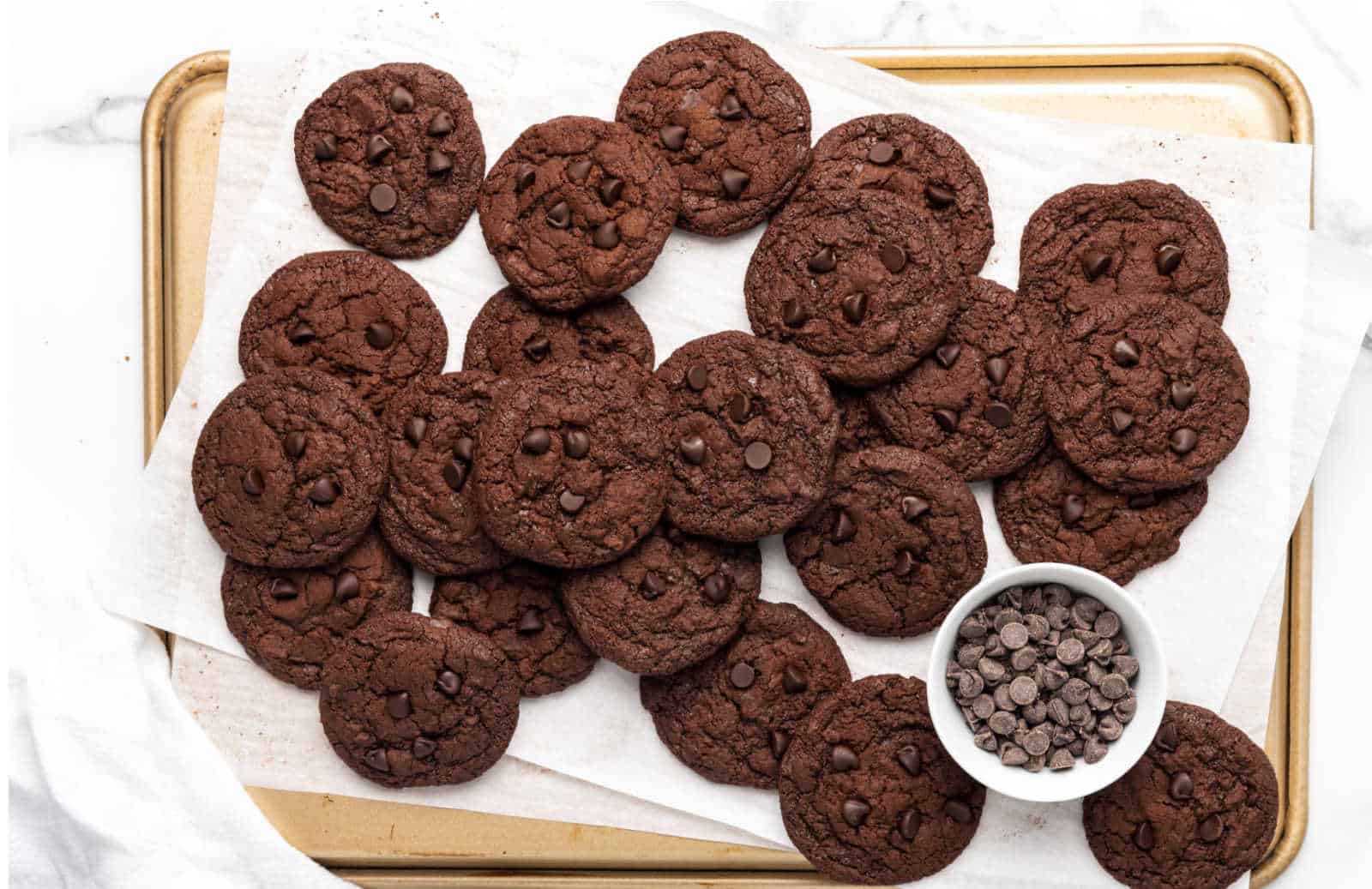 Chocolate chocolate cookies on parchment paper on a cookie sheet.